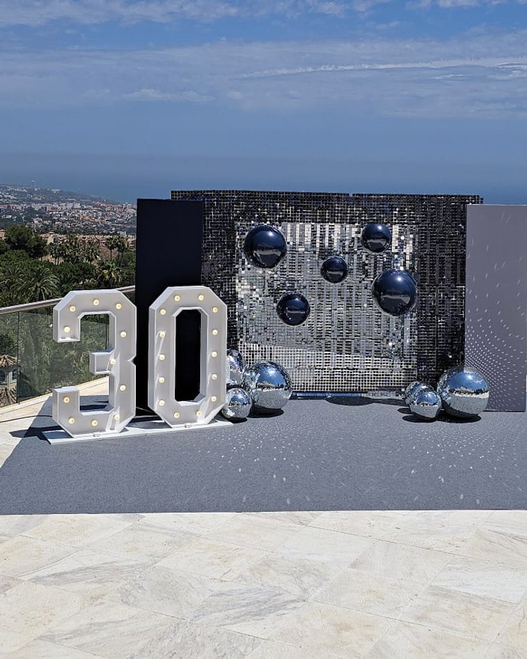 Sequin wall photocall with light-up number 30 and disco balls in Marbella — El Baúl de Zoé