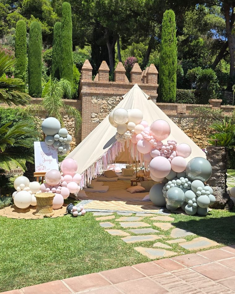 Carpa tipi decorada con globos pastel junto a un castillo en San Pedro de Alcántara — El Baúl de Zoé
